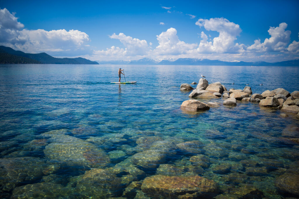 Person paddle boarding during summer in lake tahoe